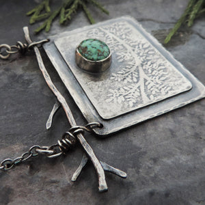 sterling silver botanical pendant with plant design and turquoise