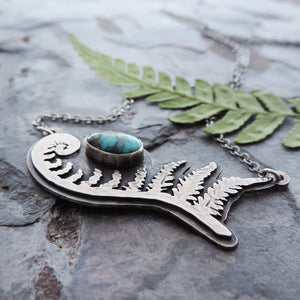 hand cut unfurling fern pendant with turquoise stone